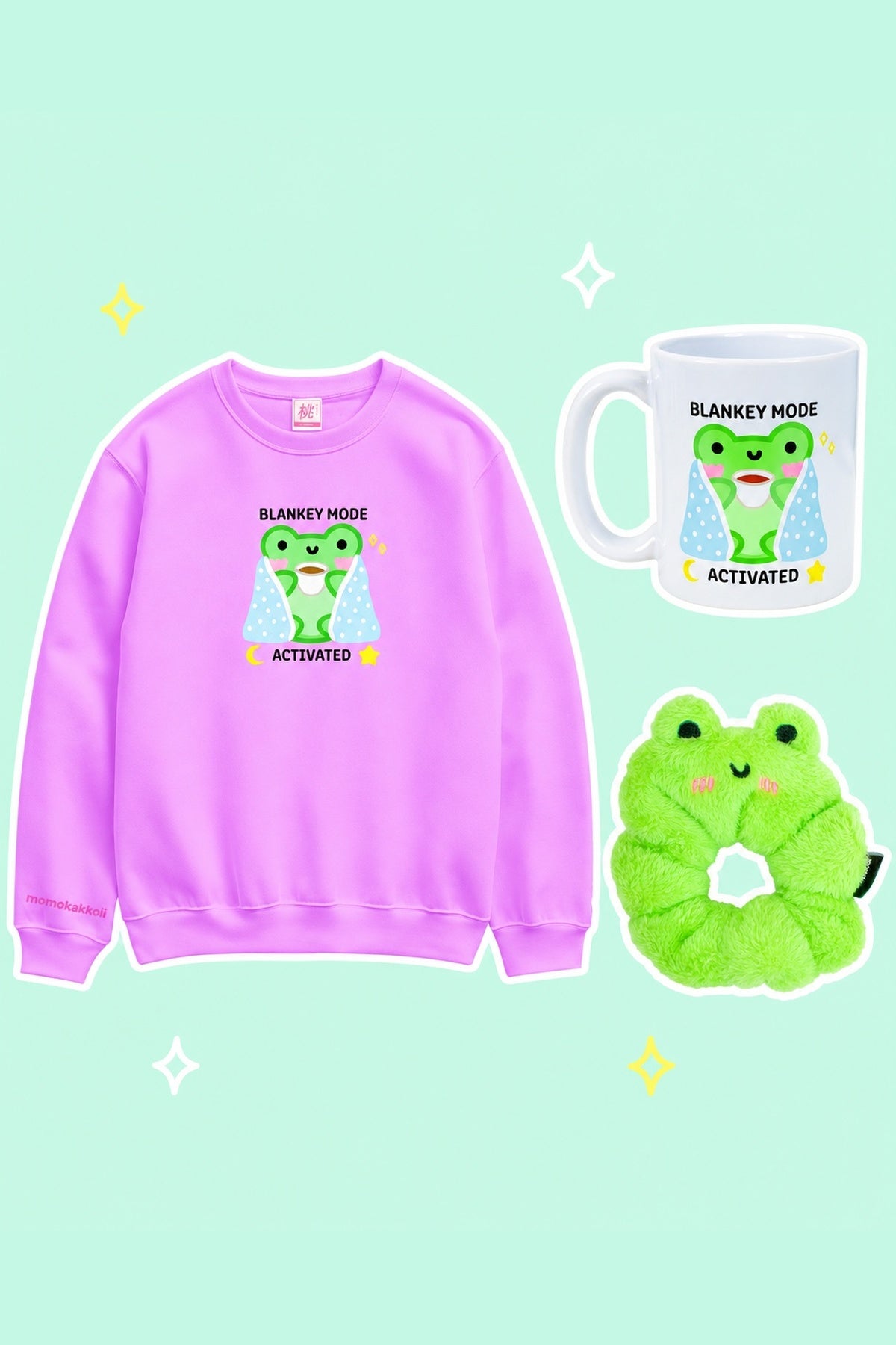 Blankey Mode Cosy Night In Bundle: one purple Blankey Mode sweatshirt, one white Blankey Mode ceramic mug, one lime-green Fluffy Albert frog scrunchie, on a simple pastel background with white outlines and small sparkles.