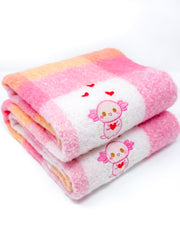 Folded pink and orange scarf with cartoon character xoxi the axolotl and heart design on a white background