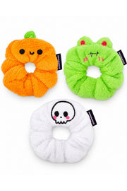 White-background product arrangement: one orange Patch the Pumpkin scrunchie with cute round black eyes and curved smile (NOT jack-o-lantern), one lime green Vampire Albert scrunchie with red eyes and fangs, one white Cute Skull scrunchie.